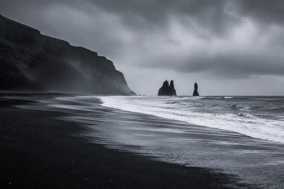 Dark sea stacks rising from the black sand coast