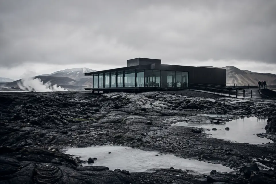 Steam rising from geothermal water between dark basalt walls